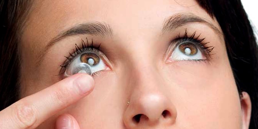 A woman putting contacts in her eyes