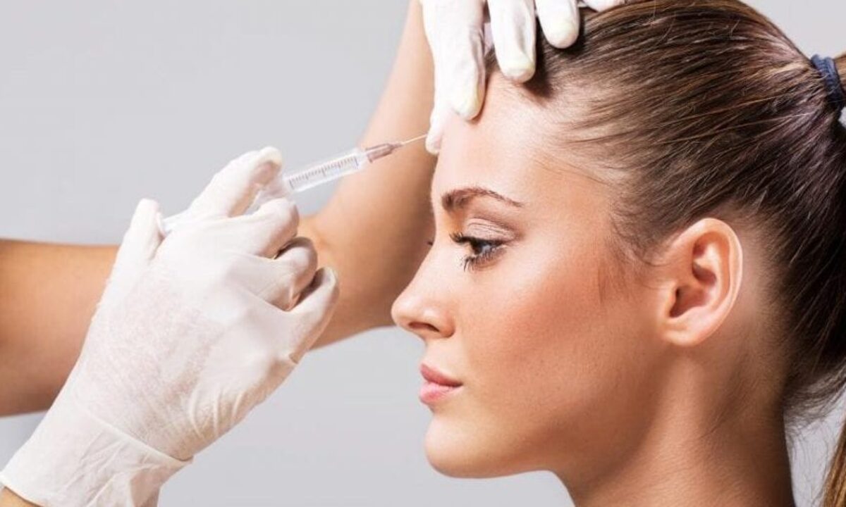 doctor injecting botox in a young ladys forehead