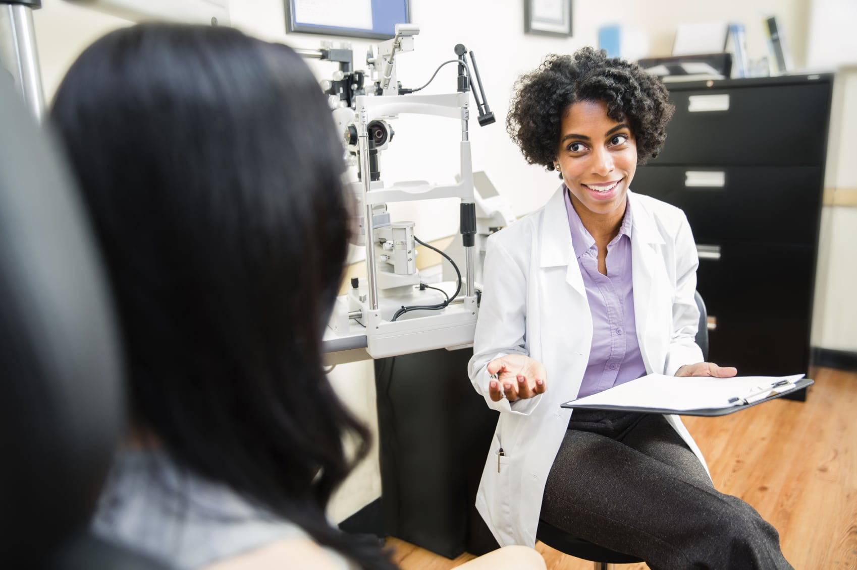 eye doctor giving a young lady an eye exam in an office