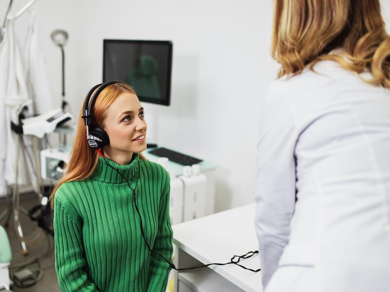 audiologist giving a young girl a hearing test