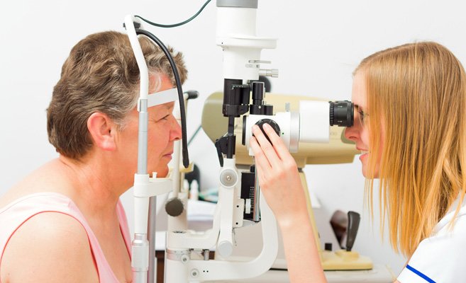 a woman doctor giving a woman patient an eye exam