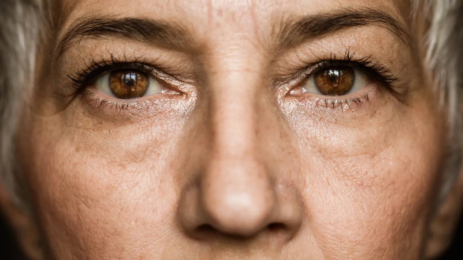 Close up of older woman with dark brown eyes