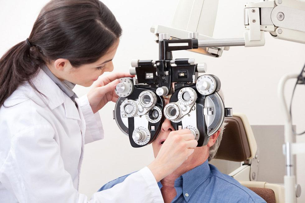 A woman doctor using a machine to analyze an individual's eye