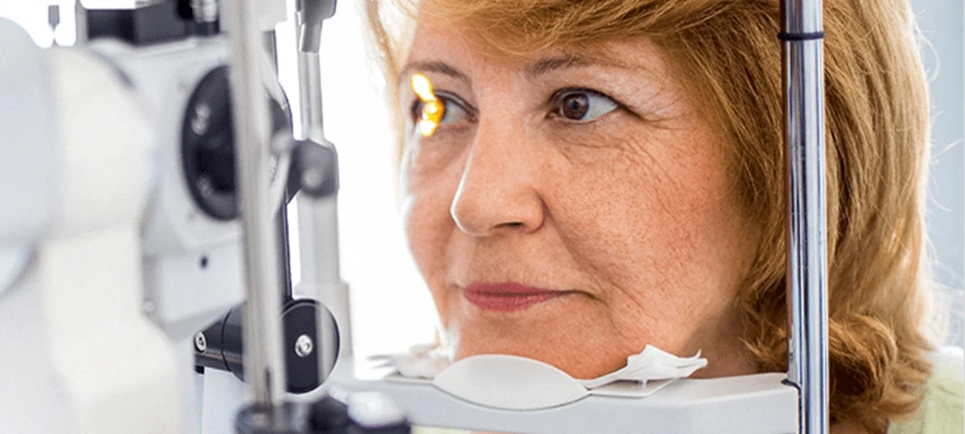 Woman looking into an eye scanner to detect cataracts