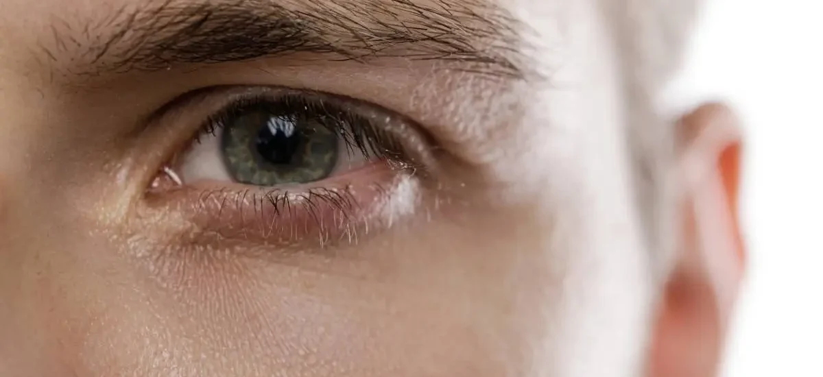 close up of a mans brown colored eye looking directly into the camera