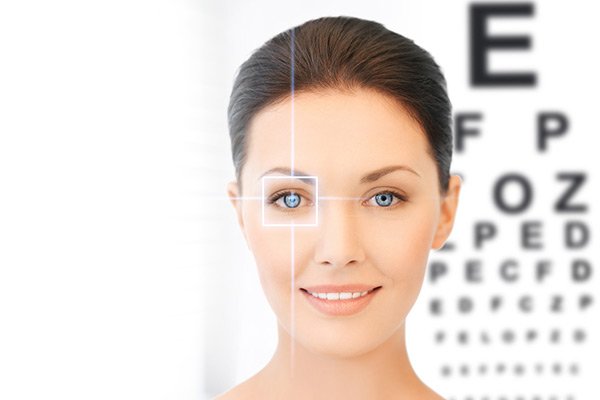 young lady standing infront of an eye exam chart