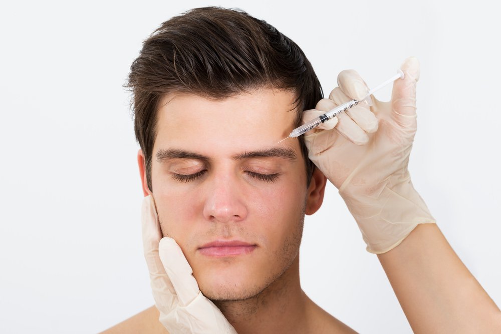 male getting botox in his forehead