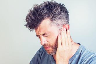 A man holding his ears in pain