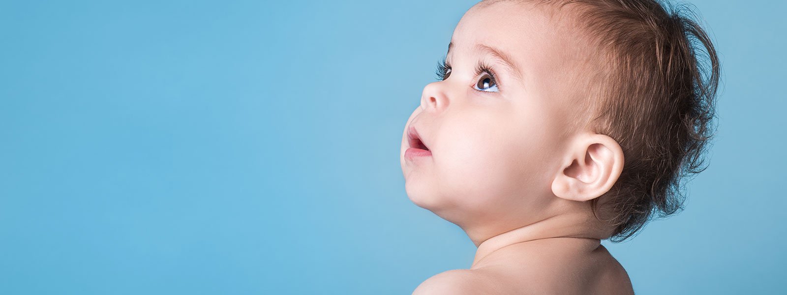 Image of baby looking up and to the left with a blue background