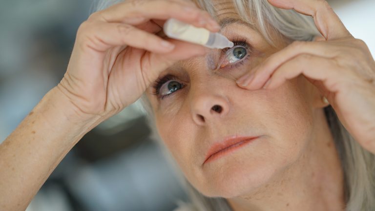 Woman administers eye drops