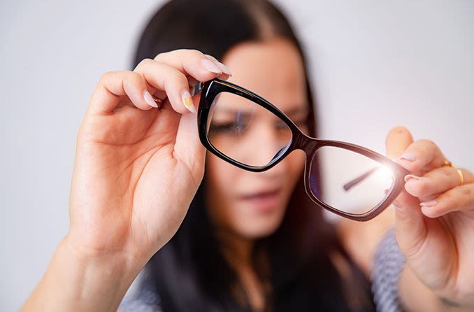 A girl examining her glasses