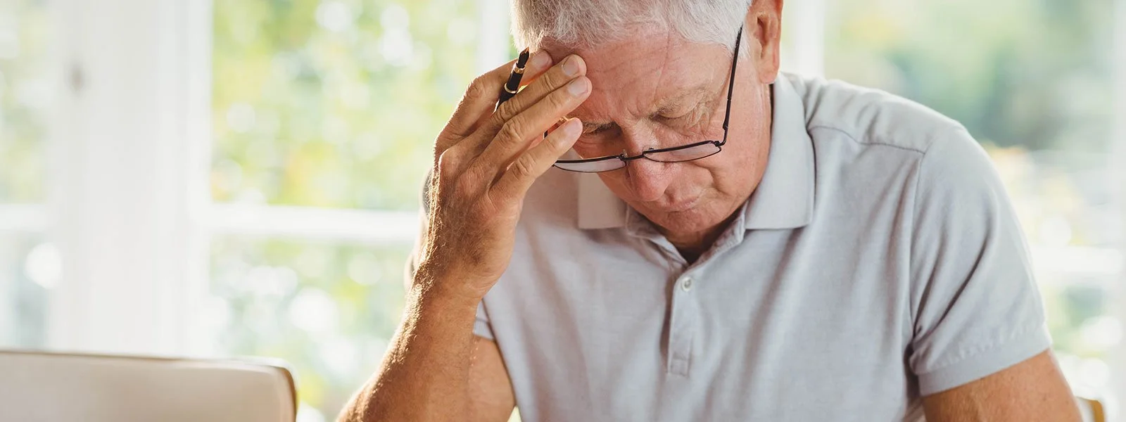 Older man holding his head due to ocular migraine