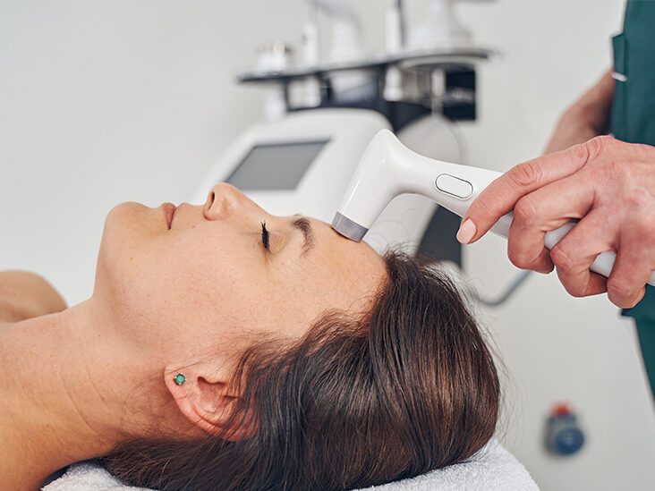 Woman lies on a table to receive laser skin tightening procedure