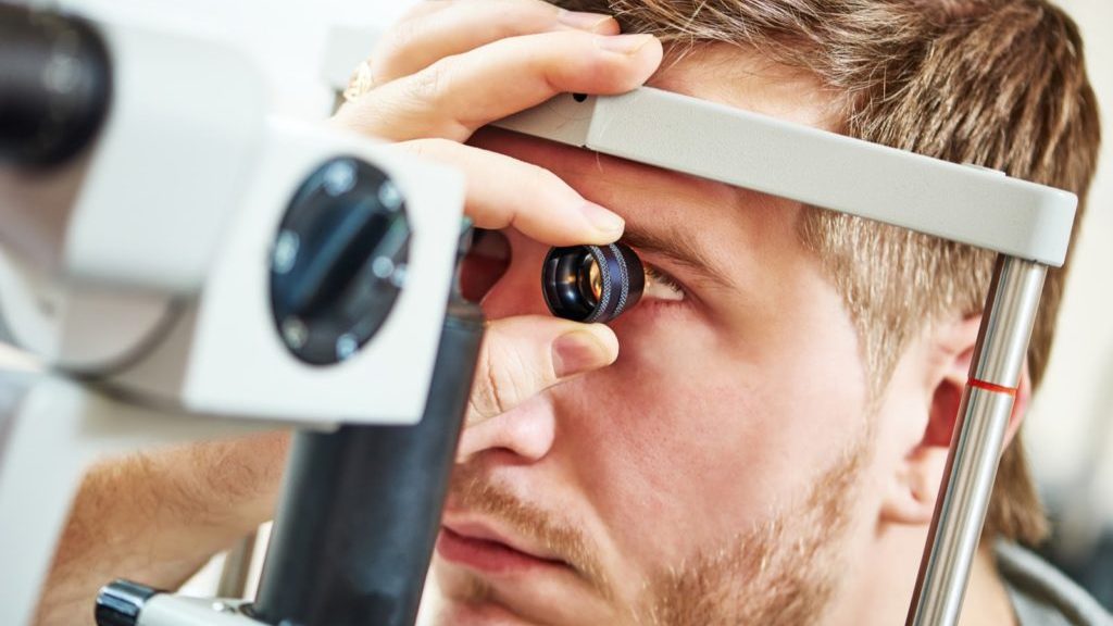 man sits with his eye doctor for an eye exam