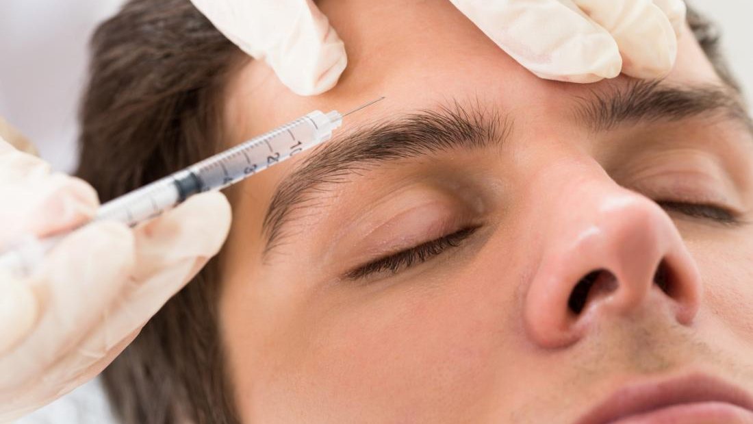 Man getting botox injection in his forehead