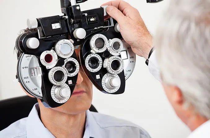man receiving an eye exam by an ophthalmologist