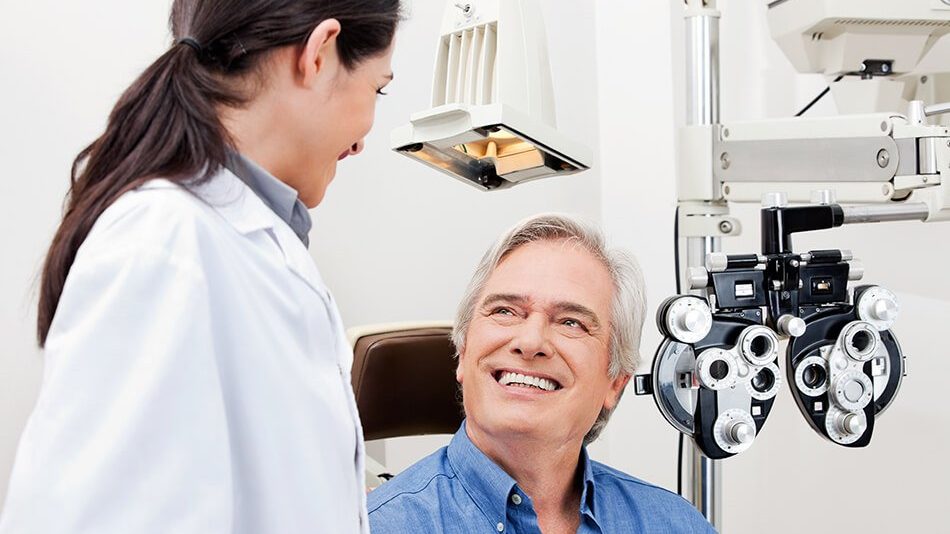 Man smiles at his eye doctor while getting an eye exam