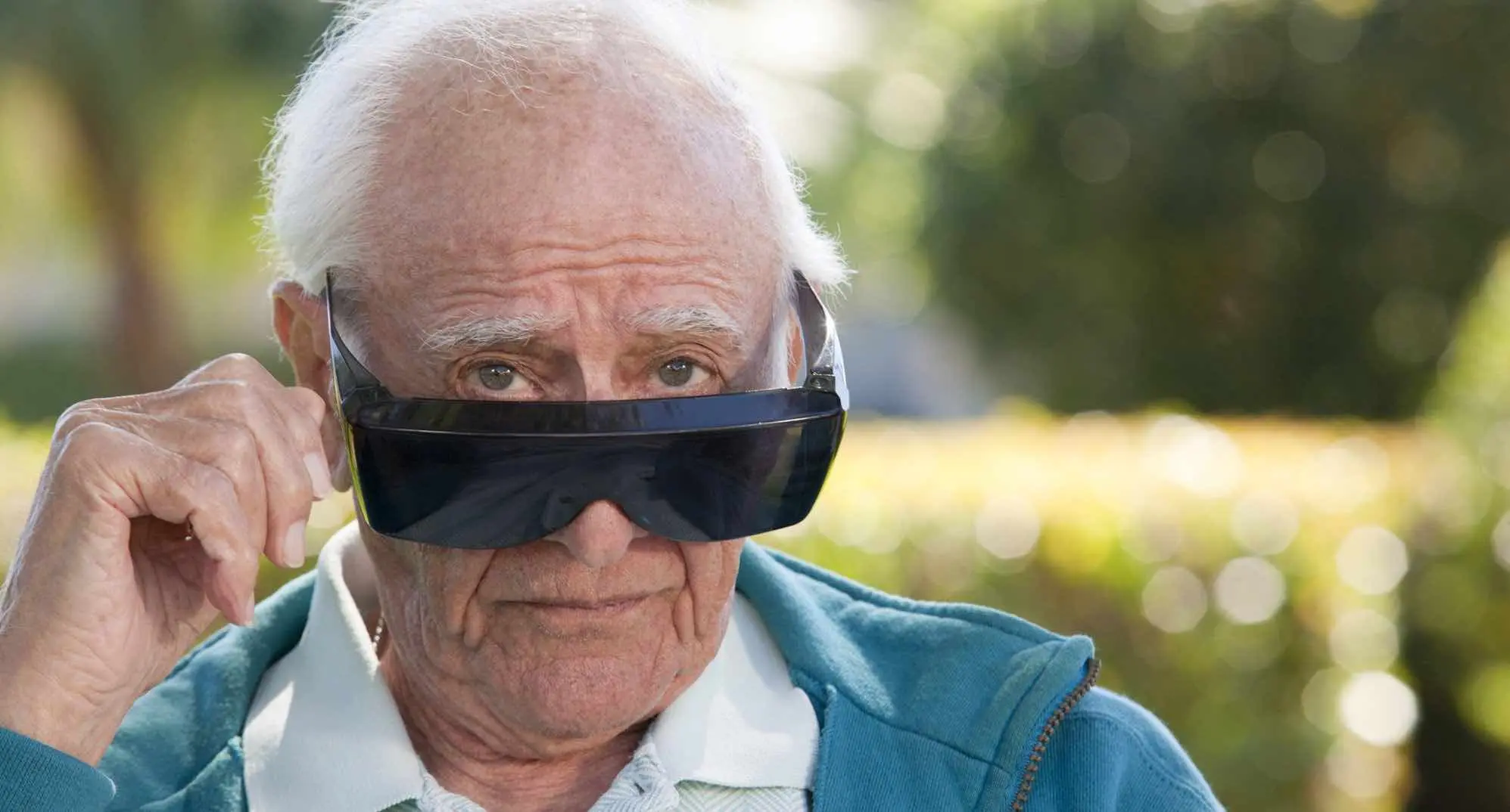 older man pulling down a pair of sunglasses