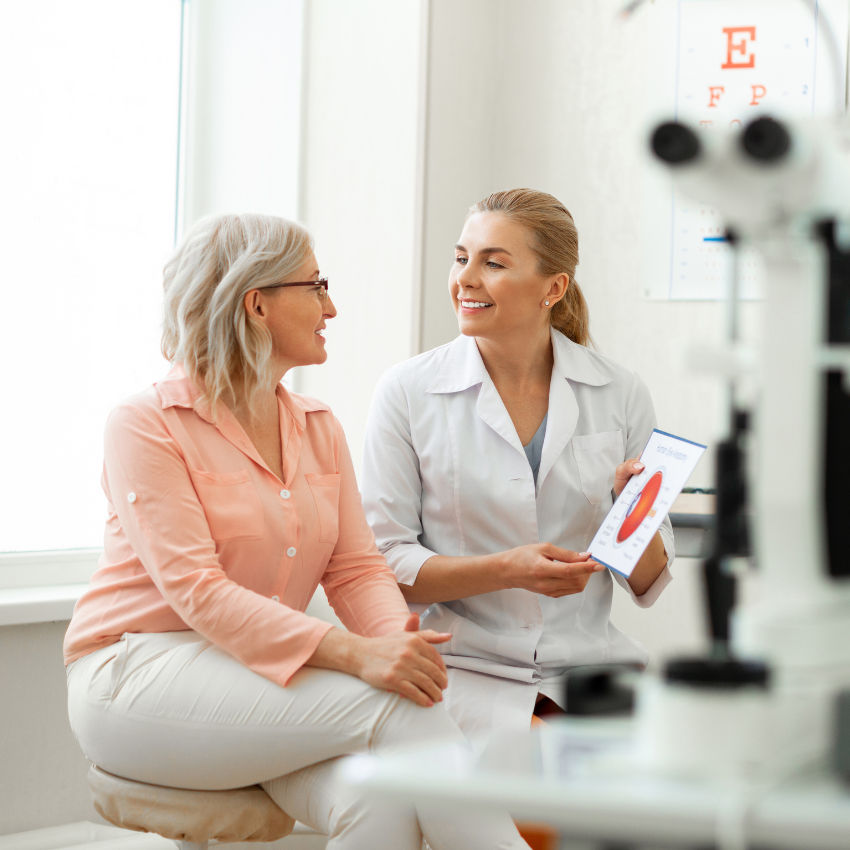 Beaming long-haired woman having appointment with older patient and discussing her issues