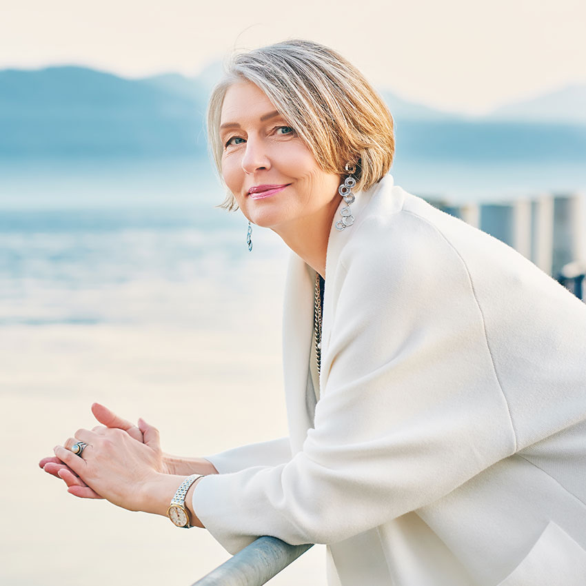 Beautiful-middle-age-woman-admiring-amazing-view-of-winter-lake-and-mountains