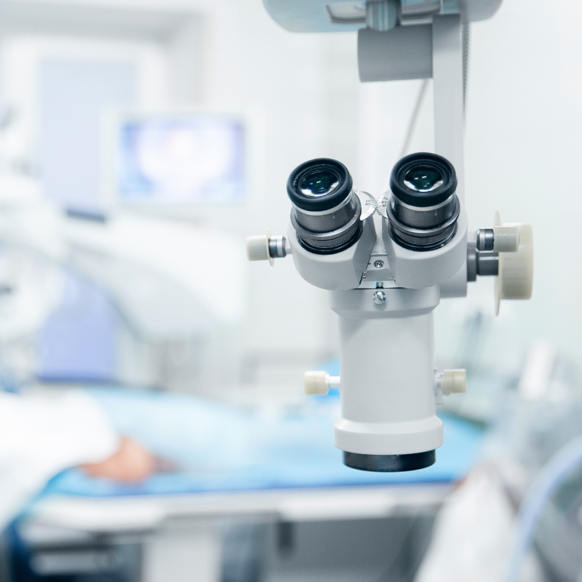 Doctor examines fundus in microscope, patient under sterile cover