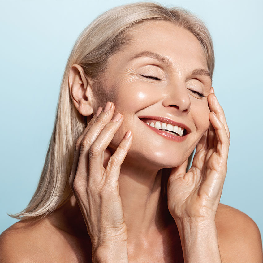 Gorgeous-senior-older-woman-with-closed-eyes-touching-her-perfect-skin