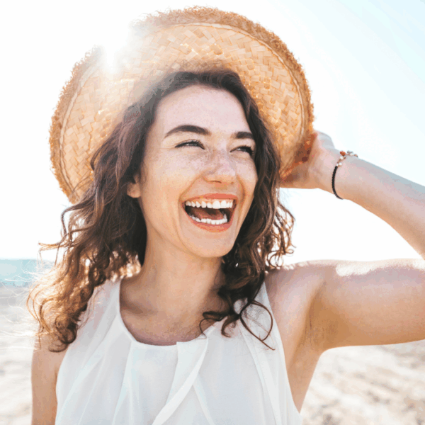 Happy beautiful young woman smiling at the beach side healthy lifestyle concept with female laughing outside