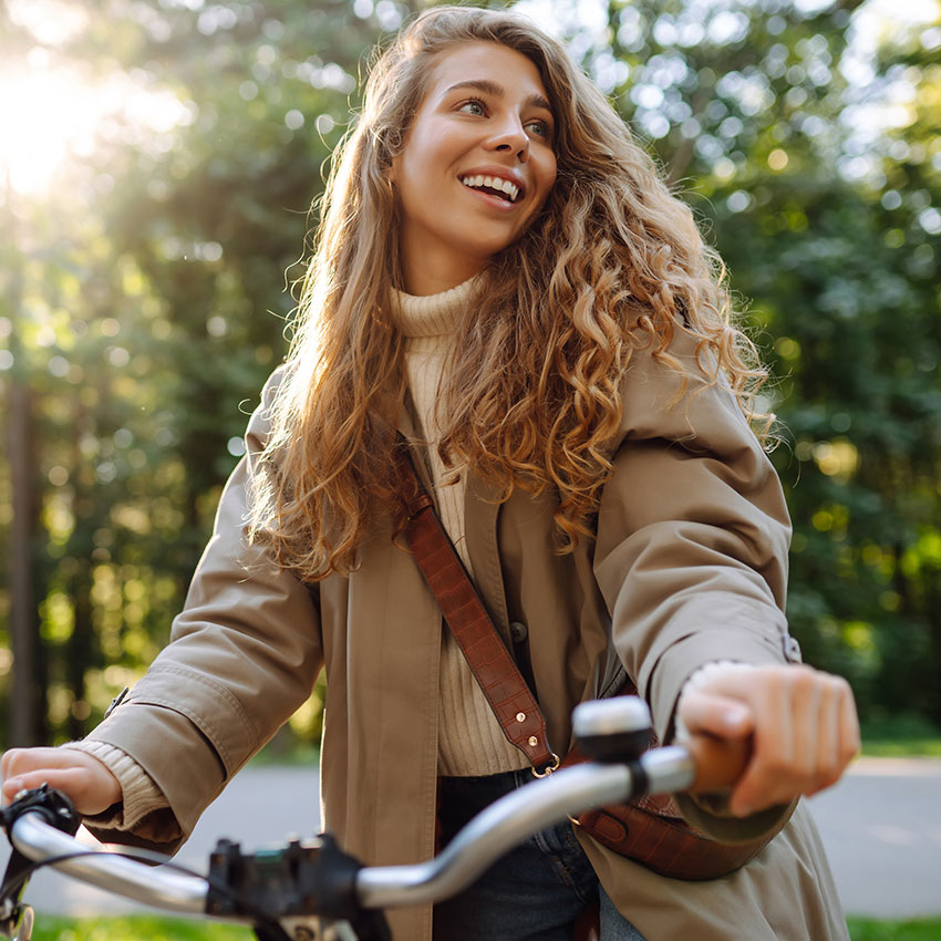 Happy-woman-tourist-woman-using-bicycle-in-the-park.--Active-lifestyle.-The-concept-of-nature.