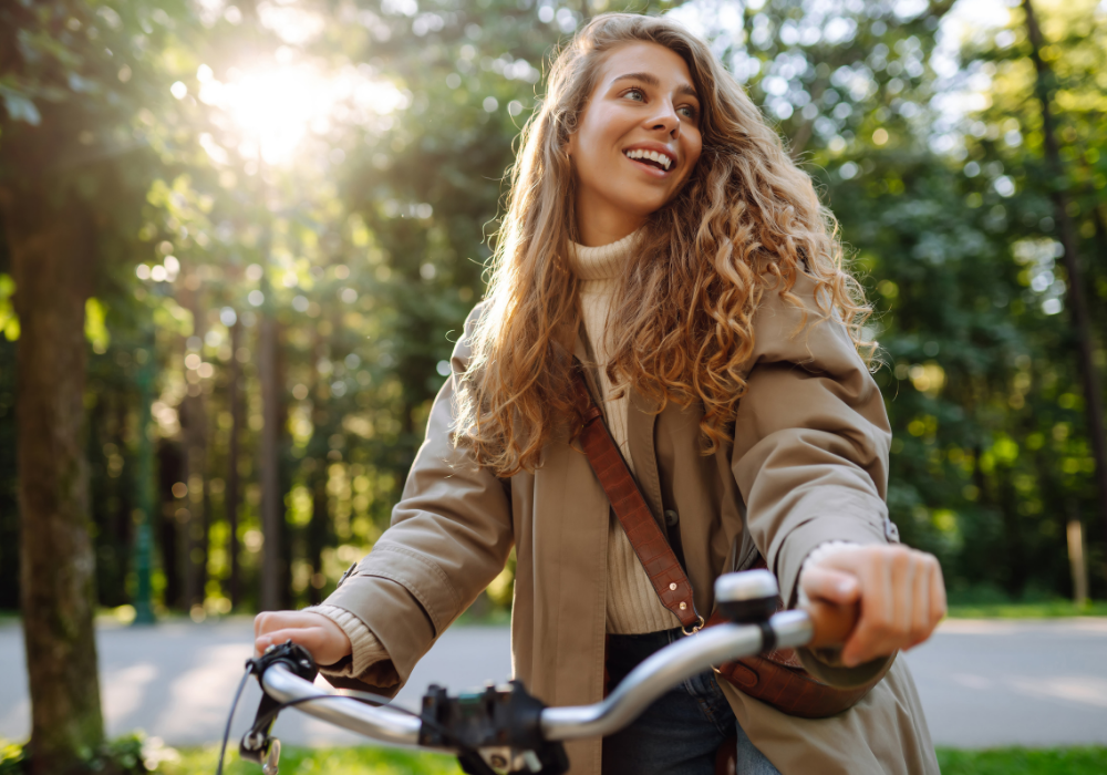 Happy woman tourist woman using bicycle in the park