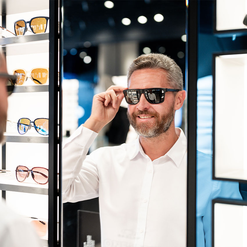Man-in-sunglasses-indoors-portrait.-Mature-guy-choosing-eyeglasses.-Man-in-trendy-eyewear