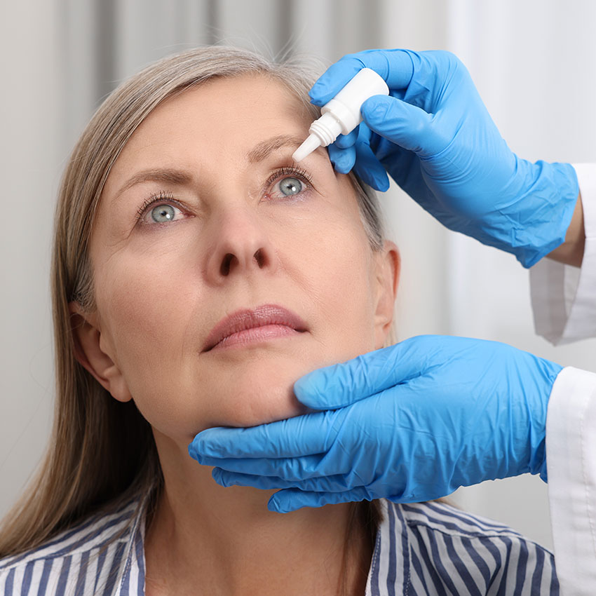 Medical-drops.-Doctor-dripping-medication-into-woman's-eye-indoors