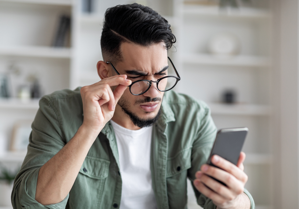 Millennial Guy Trying To Read Message, Suffering From Astigmatism And Bad Vision
