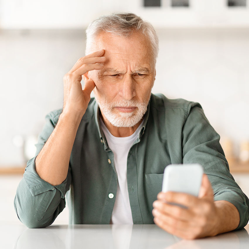 Myopia-Concept.-Senior-man-squinting-while-looking-at-smartphone-screen