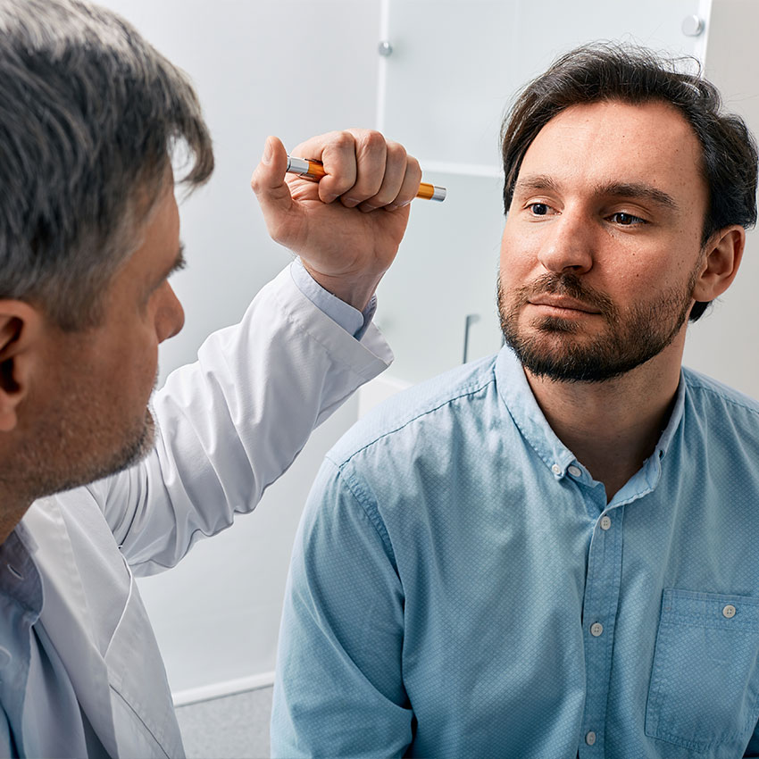 Neurologist-doctor-examining-male-patient,-checking-basic-reflexes-of-human-by-shining-flashlight-into-his-eyes.-Neurologist's-consultation,-neurology