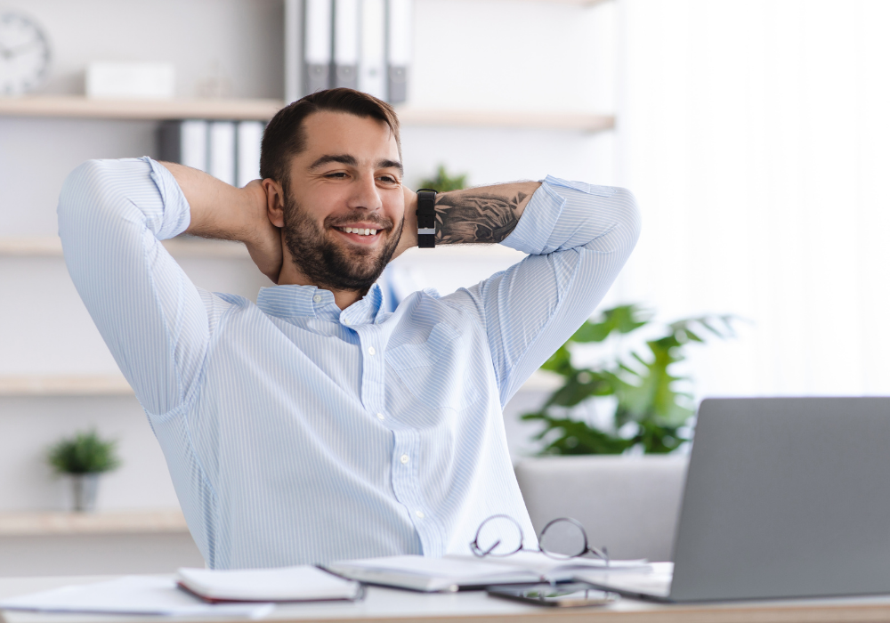 Smiling mature european male with beard take a break from work at laptop in office or living room interior