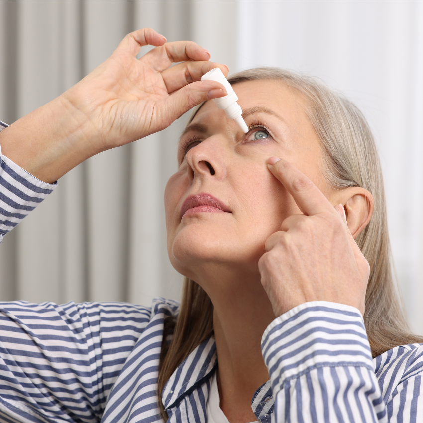Woman applying medical eye drops at home