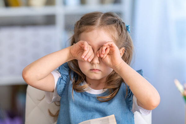 child-is-tired-of-learning.-home-schooling,-homework.-girl-rubs-his-eyes-from-fatigue-reading-books-and-textbooks