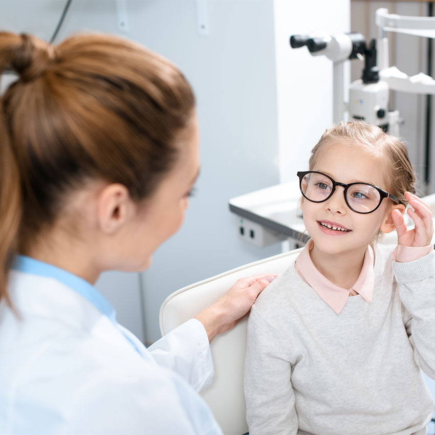 ophthalmologist-and-smiling-kid-in-eyeglasses-in-optics