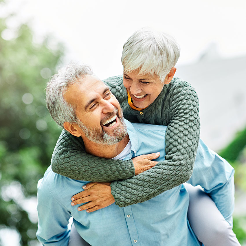 woman man outdoor senior couple happy lifestyle retirement together smiling love piggyback active mature