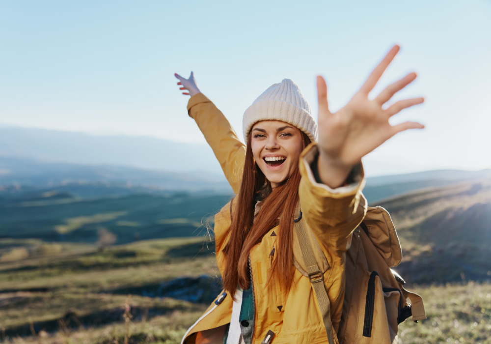 woman traveler in a yellow jacket in a hat backpack travel mountains Fresh air