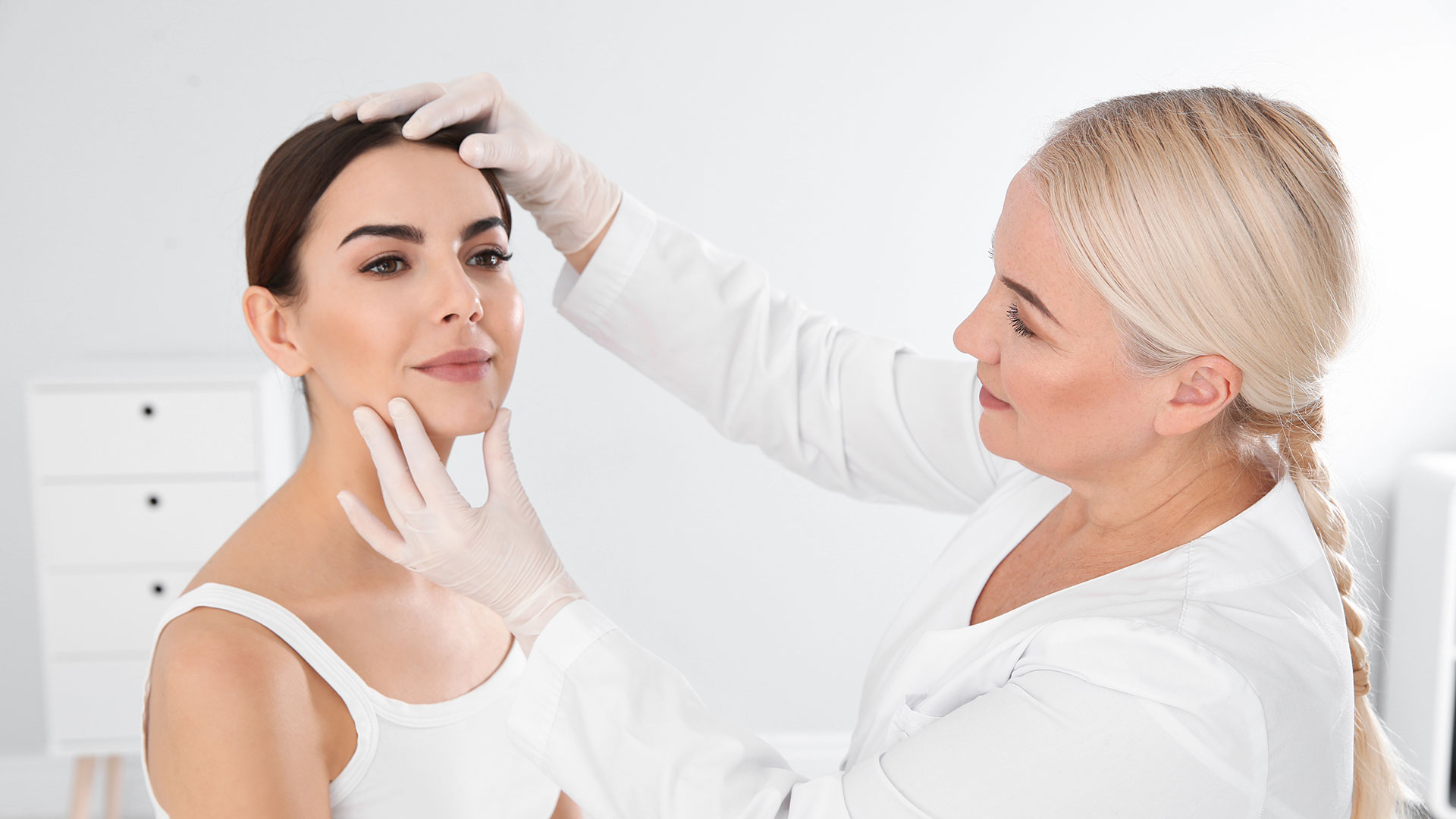 Dermatologist-examining-young-patient's-birthmark-in-clinic