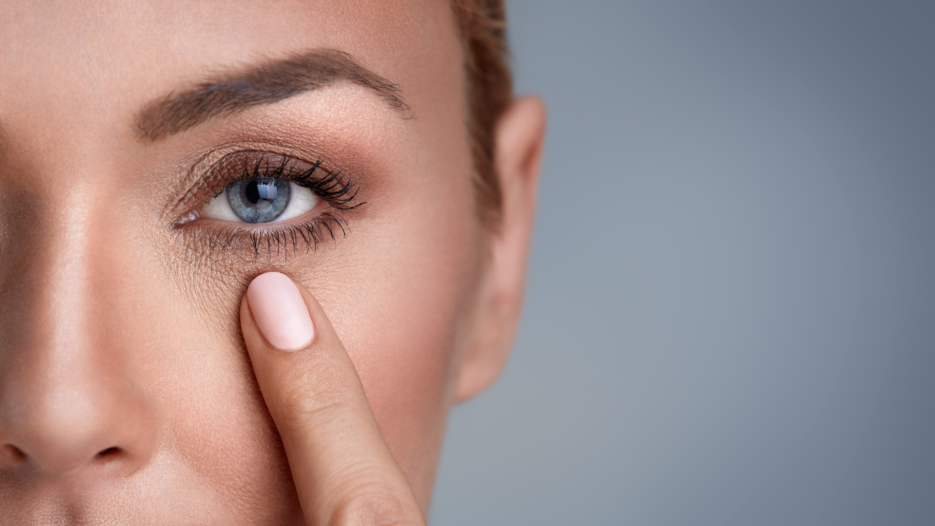 Portrait of woman up close pointing with one finger to eye