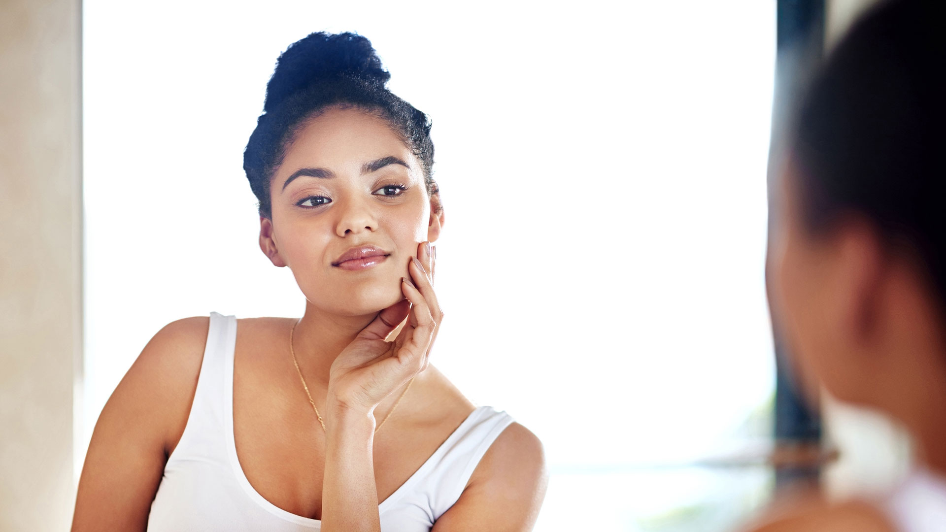 Skincare,-beauty-and-woman-at-mirror-in-bathroom-for-dermatology,-wellness-and-morning-routine-for-hygiene-in-home