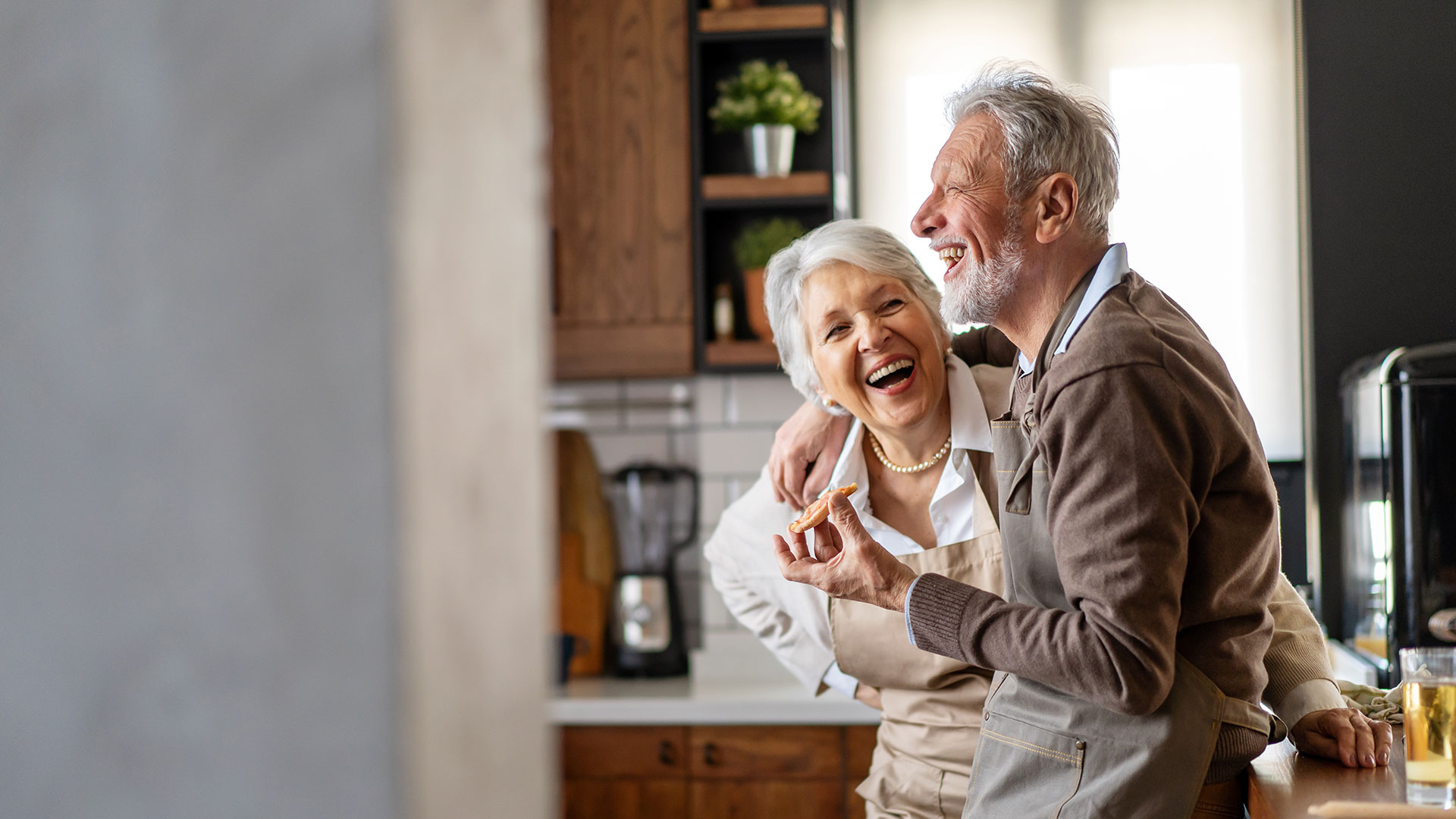 Happy-senior-couple-communicating-while-having-fun-in-the-kitchen-together