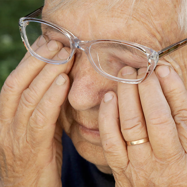 Senior-caucasian-woman-rubbing-her-eyes-under-eyeglasses
