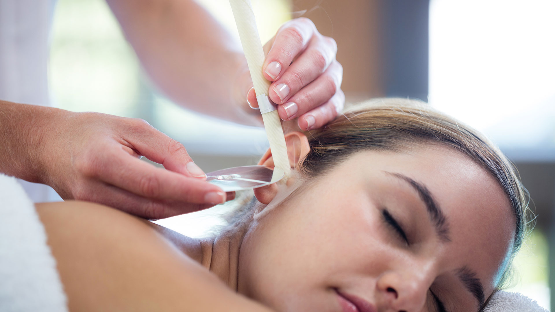 Woman-receiving-ear-candle-treatment