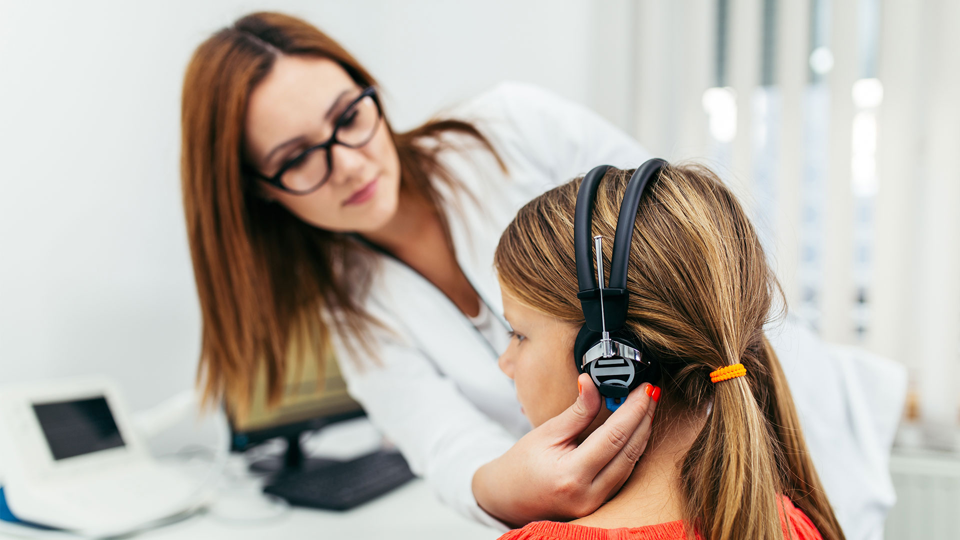 Young-girl-at-medical-examination-or-hearing-aid-checkup-in-otolaryngologist's-office