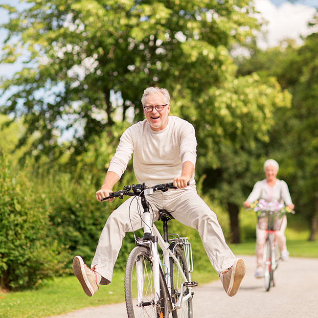 happy-senior-couple-riding-bicycles-at-summer-park