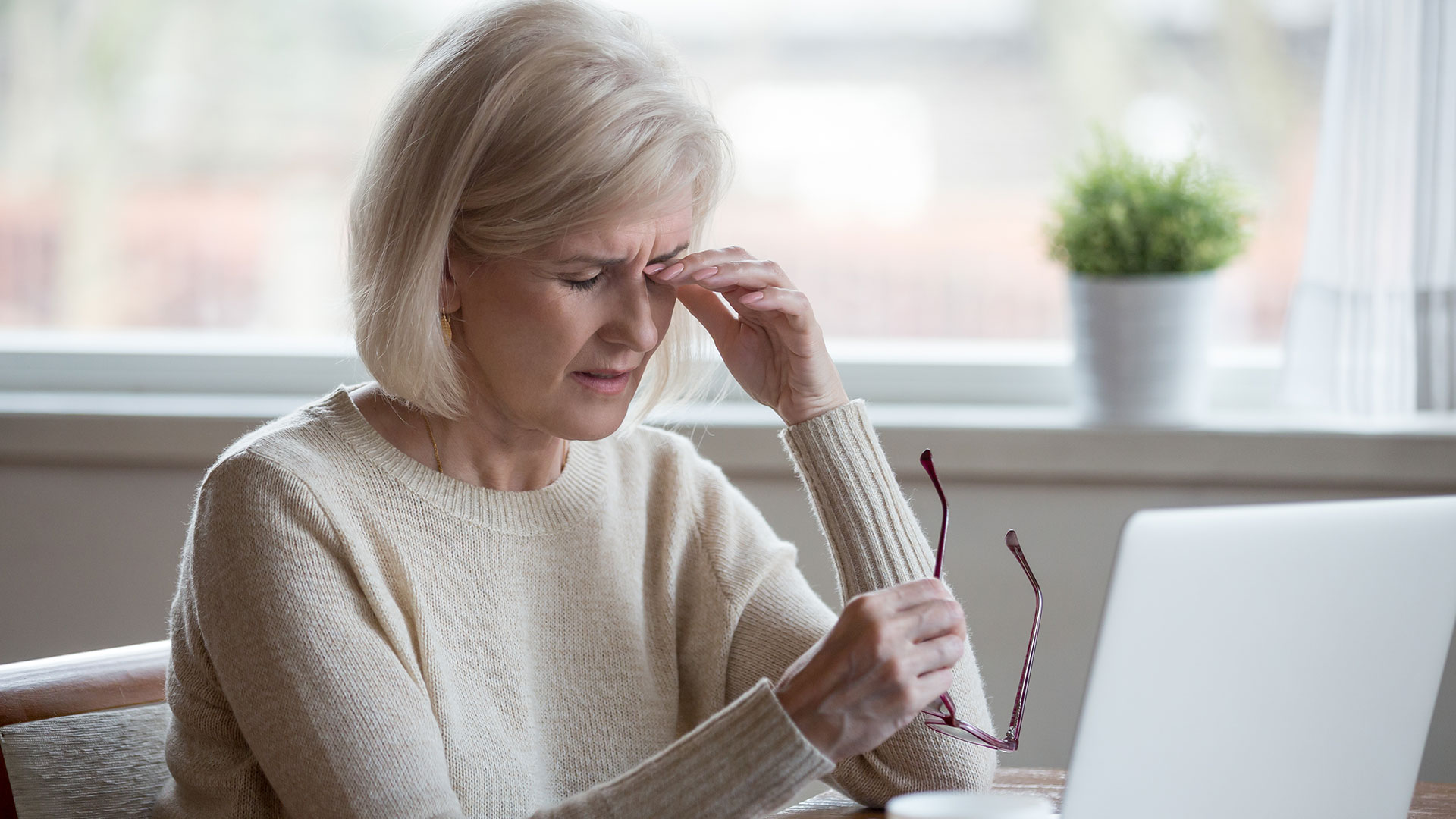 Upset-fatigued-overworked-senior-mature-business-woman-taking-off-glasses-tired-of-computer-work