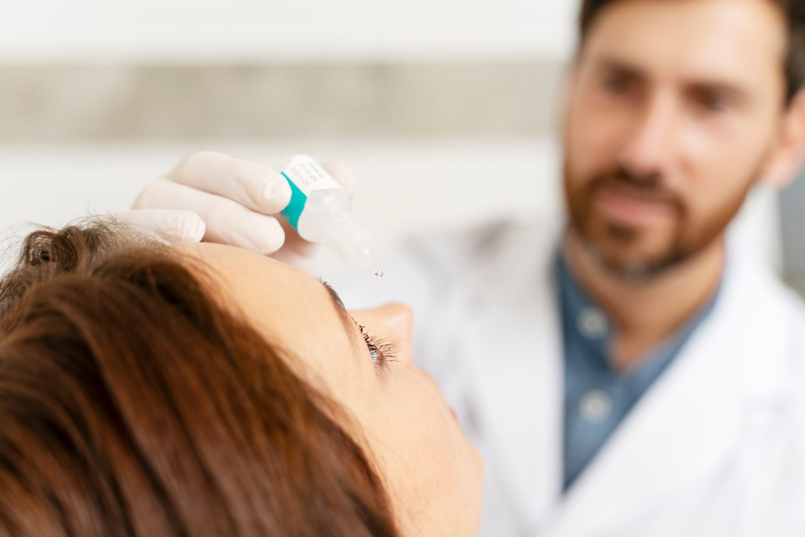Eye Doctor puts eye drops in patient